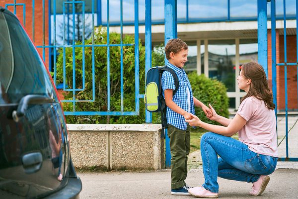 Mother dropping child off at school demonstrating safety from school intercom system